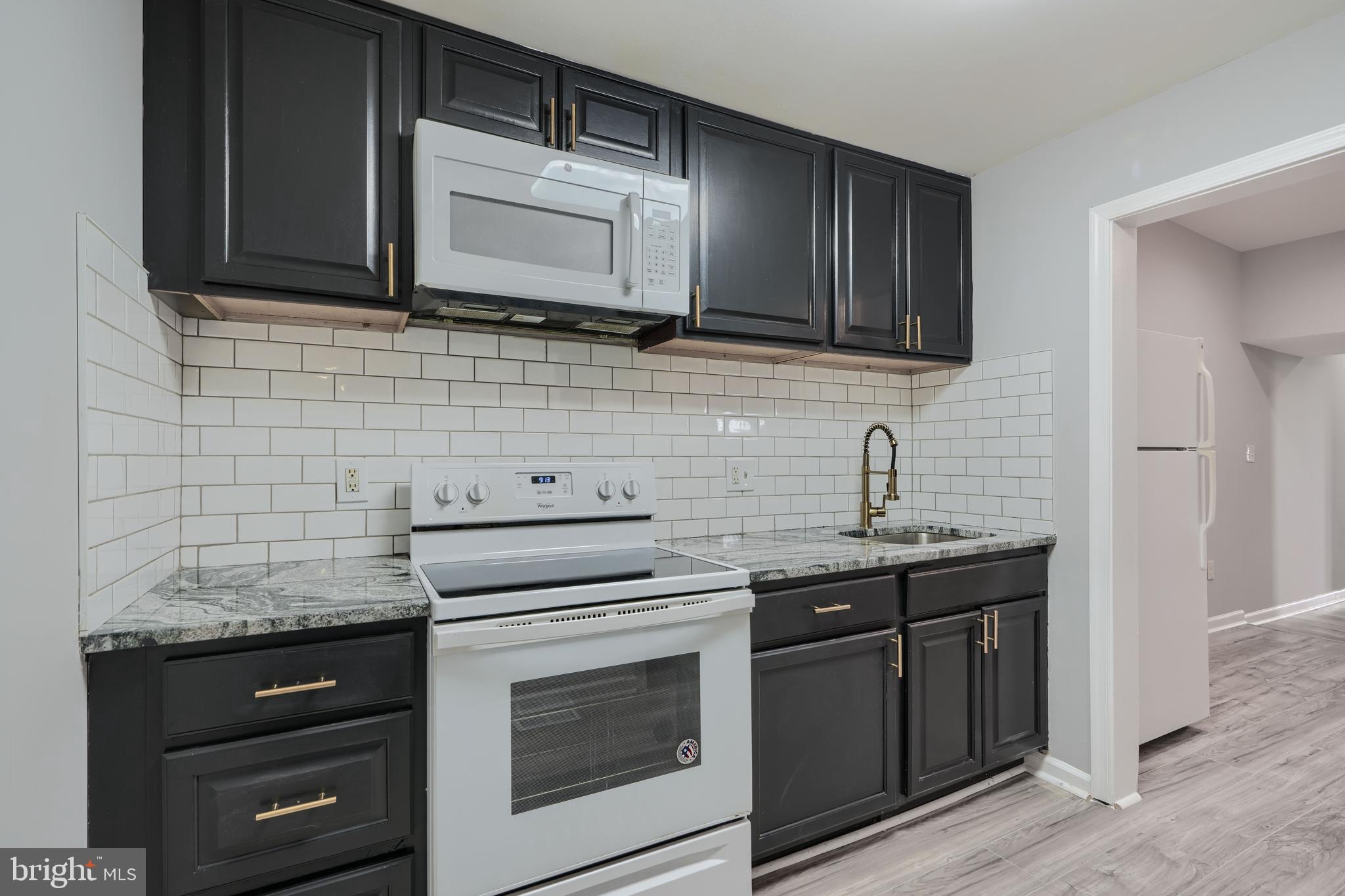 3014 Hamilton Avenue, Unit 1 Baltimore, MD 21214 - Photo 13 of 36 a kitchen with granite countertop cabinets stainless steel appliances and a sink