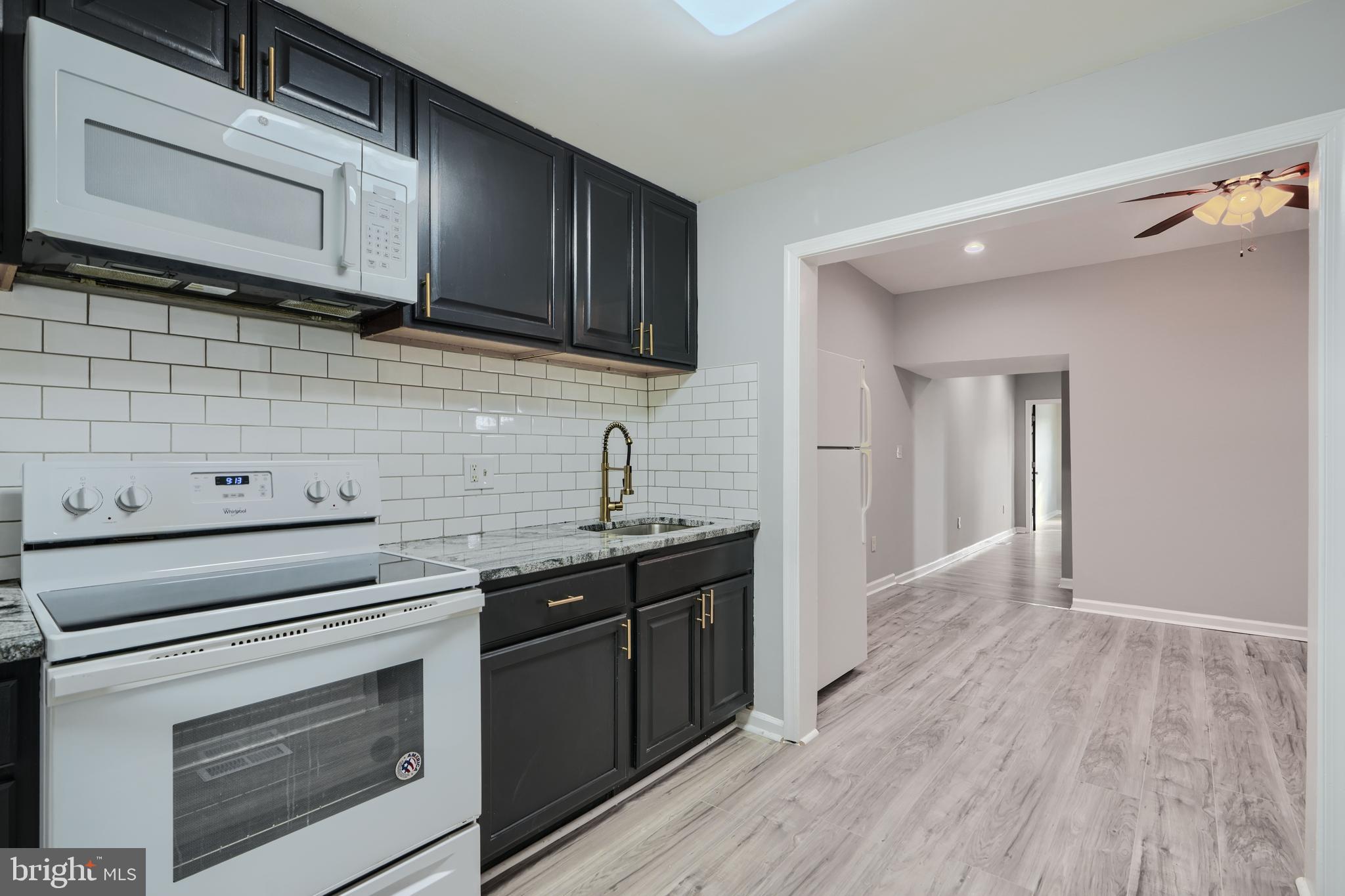 3014 Hamilton Avenue, Unit 1 Baltimore, MD 21214 - Photo 15 of 36 a kitchen with stainless steel appliances wooden cabinets and a stove top oven