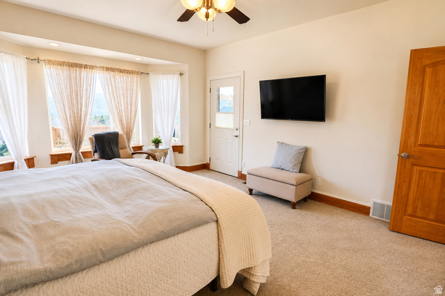 1055 North 1000 East Mapleton, UT 84664 - Photo 16 of 112 Carpeted room featuring a ceiling fan, a wall-mounted television, and a bay window with a door providing exterior access
