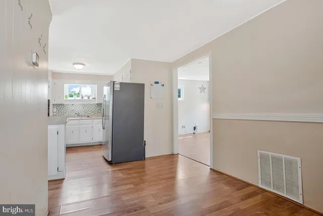 a view of a refrigerator in kitchen and wooden floor