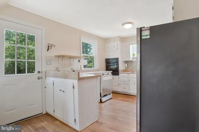 a kitchen with white cabinets and sink