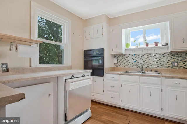a kitchen with white cabinets and refrigerator