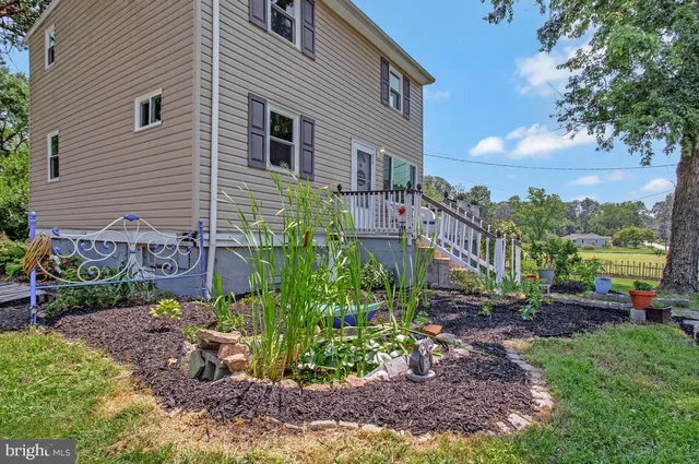 a view of a garden with a bench under an umbrella