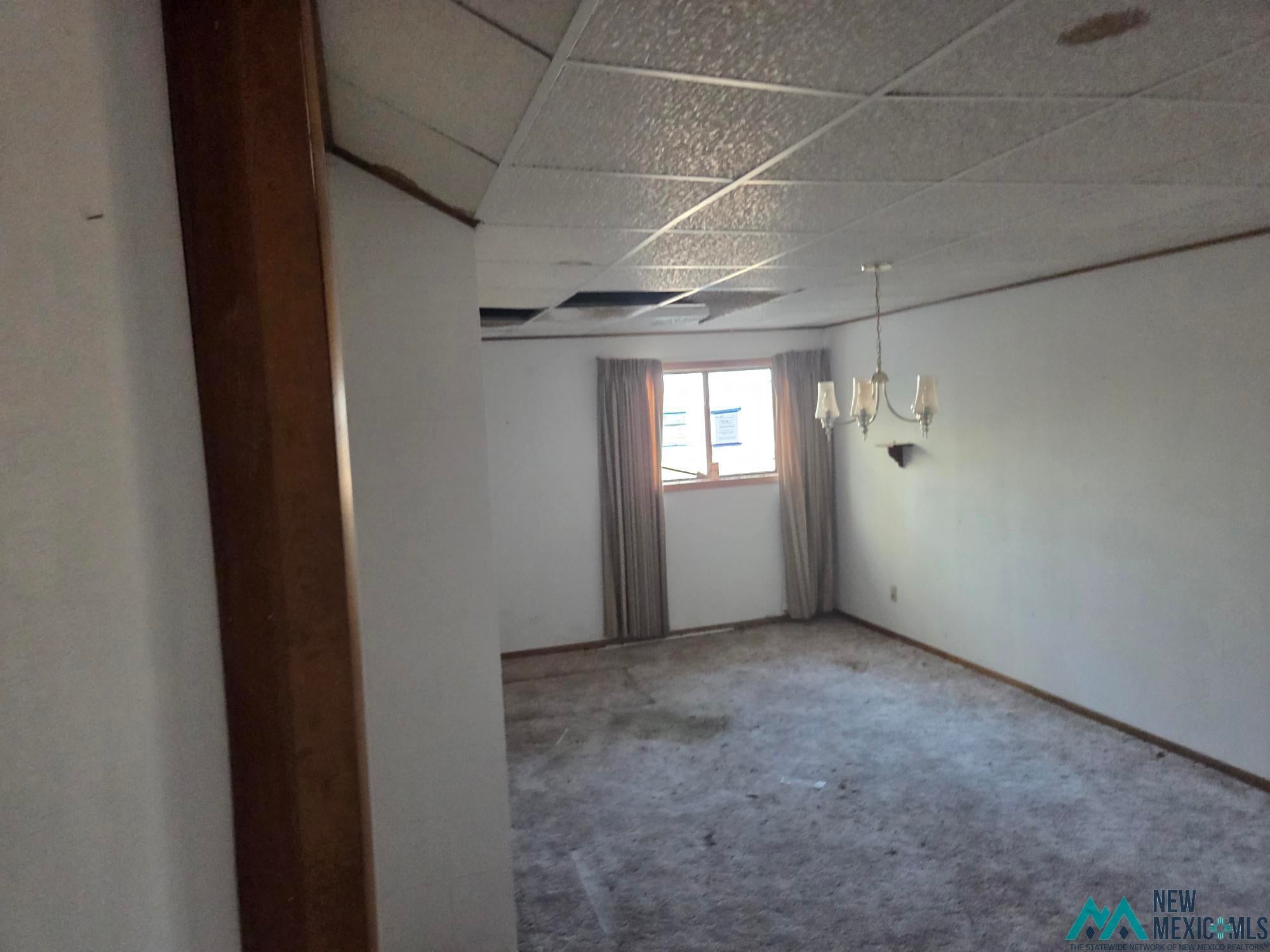 1522 Hogan Street Raton, NM 87740 - Photo 7 of 13 Carpeted spare room with a paneled ceiling