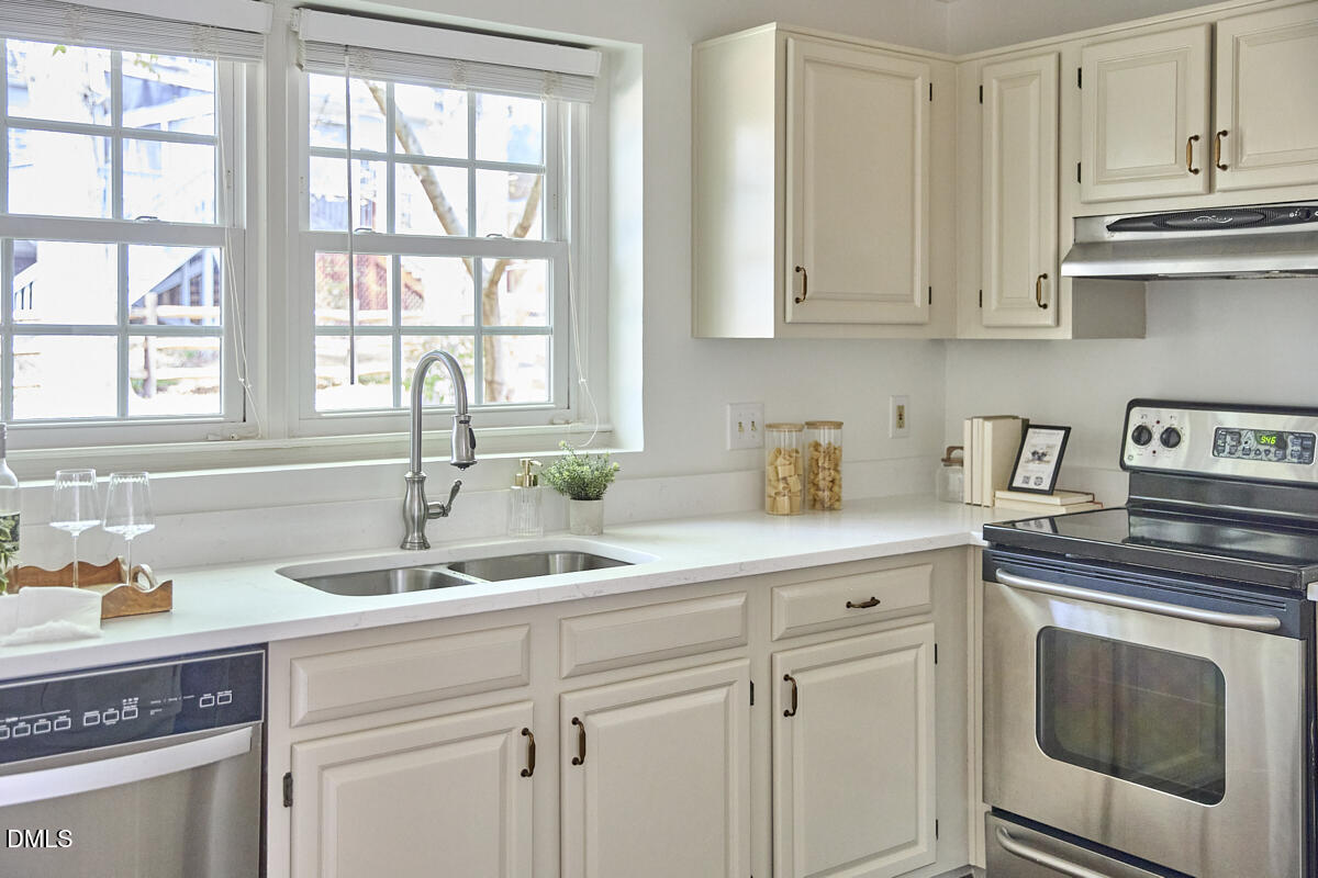 5220 Oakbrook Drive Durham, NC 27713 - Photo 10 of 38 a kitchen with white cabinets and a sink