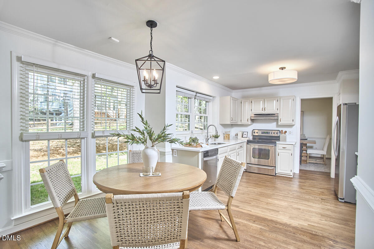5220 Oakbrook Drive Durham, NC 27713 - Photo 13 of 38 a dining room with furniture a chandelier and wooden floor