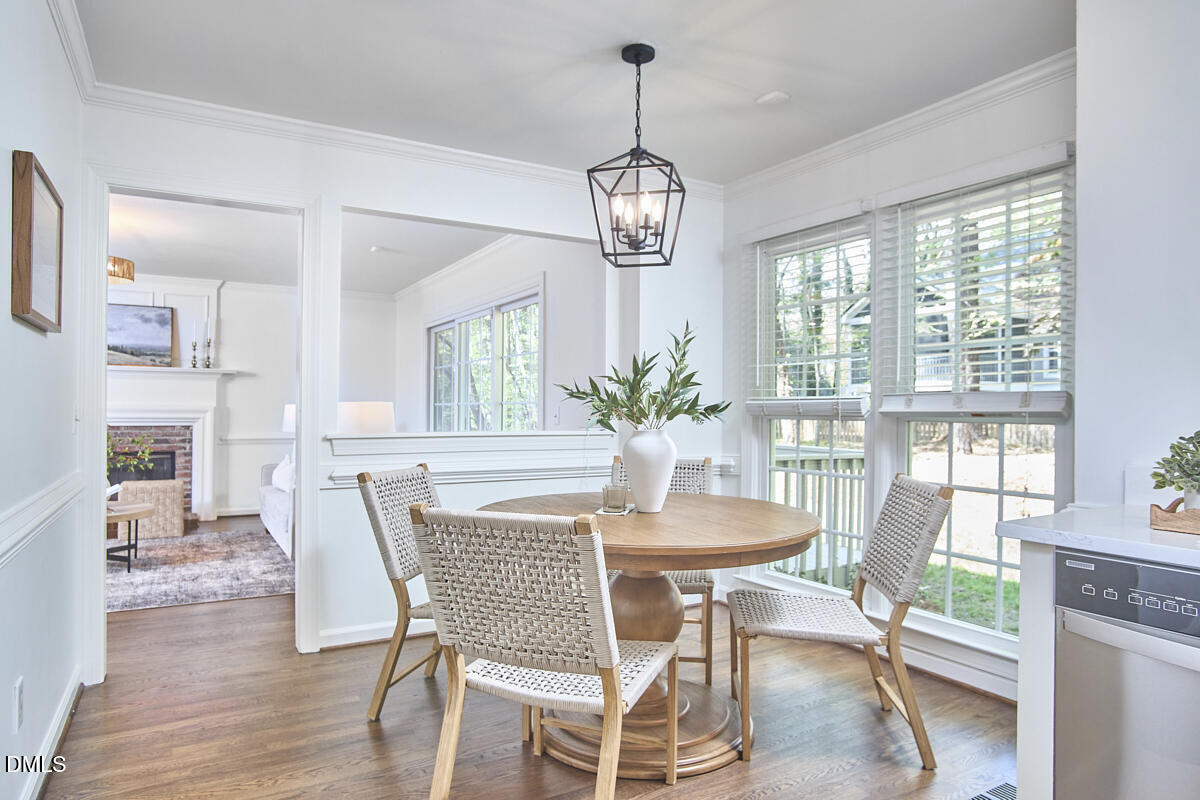 5220 Oakbrook Drive Durham, NC 27713 - Photo 14 of 38 a dining room with furniture a chandelier and wooden floor