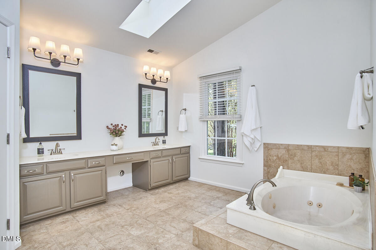 5220 Oakbrook Drive Durham, NC 27713 - Photo 21 of 38 a bathroom with a tub sink and mirror