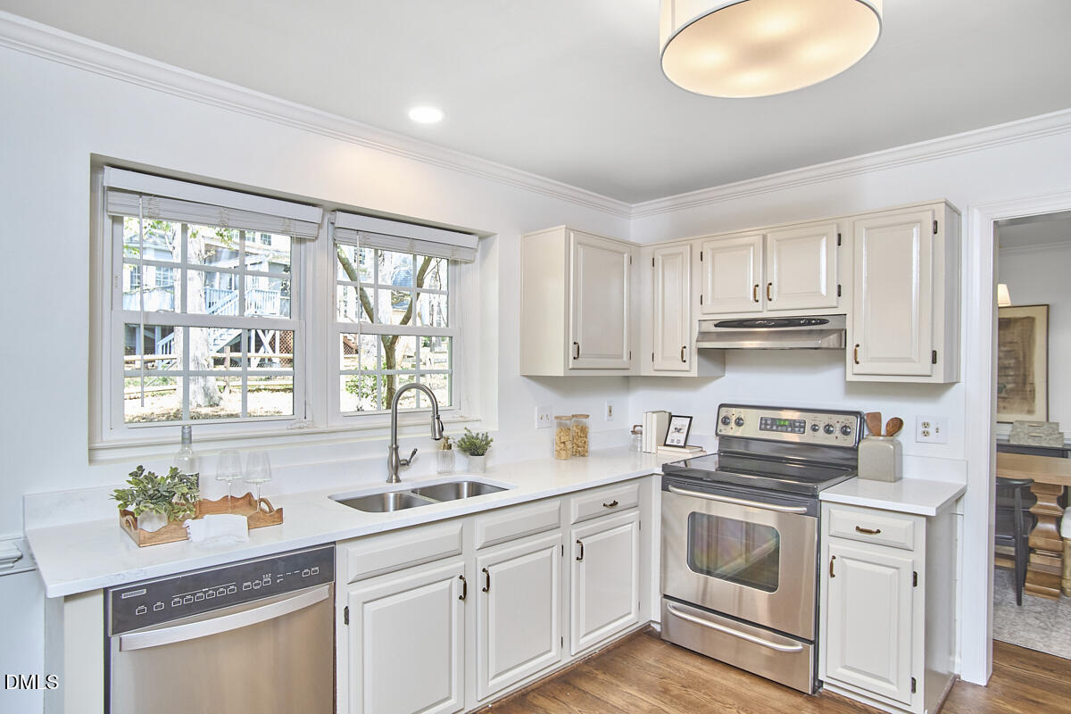 5220 Oakbrook Drive Durham, NC 27713 - Photo 8 of 38 a kitchen with stainless steel appliances white cabinets and a stove top oven