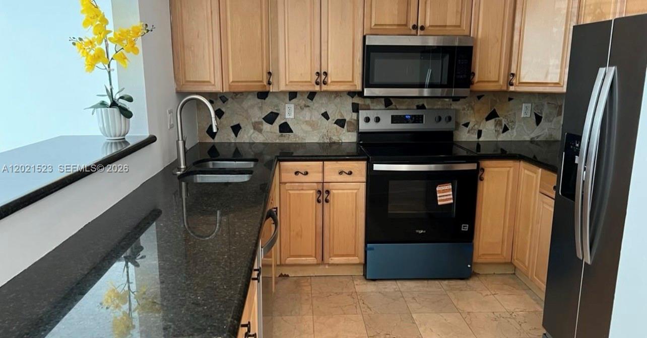 9159 Southwest 77th Avenue, Unit 101 Miami, FL 33156 - Photo 4 of 12 a kitchen with a sink and a stove top oven