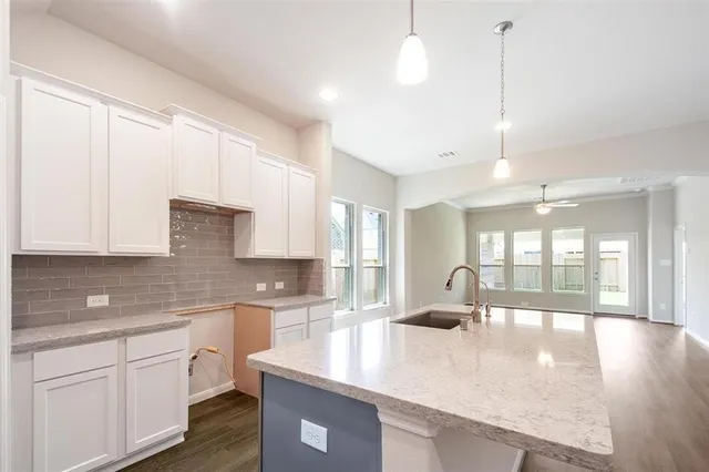 a kitchen with a large window appliances and cabinets