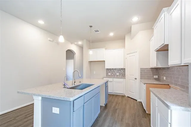 a kitchen with a sink cabinets and wooden floor