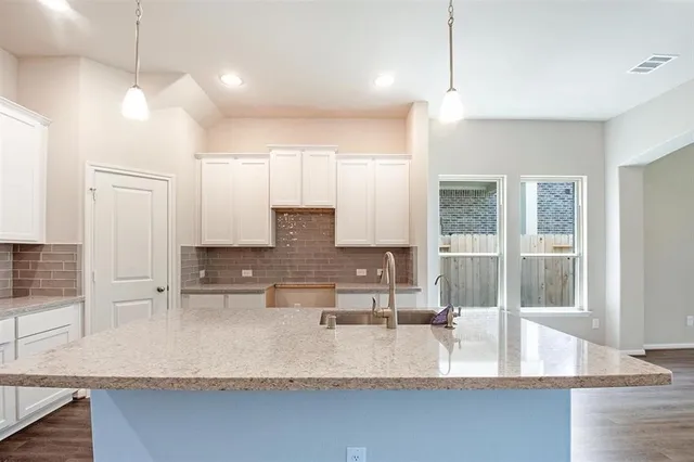 a large kitchen with kitchen island a large counter top space a sink and appliances