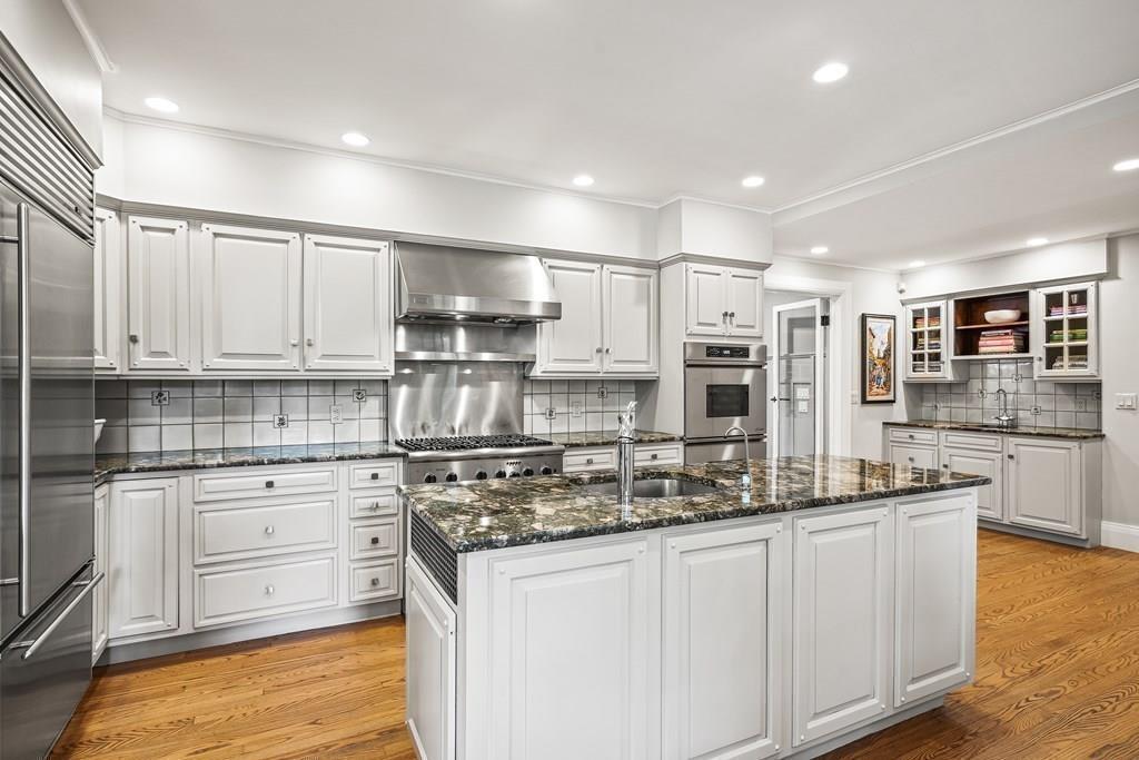 62-66 Temple Road Wellesley, MA 02482 - Photo 15 of 36 a kitchen with kitchen island granite countertop white cabinets and stainless steel appliances