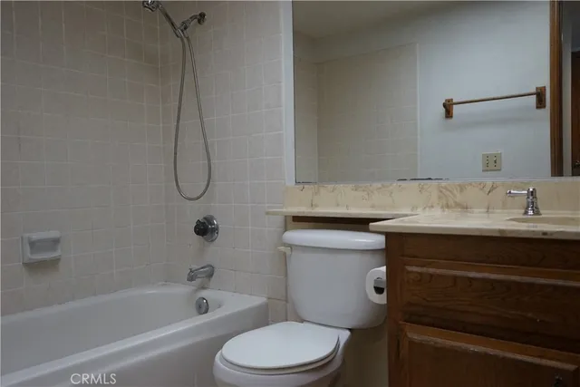 a bathroom with a granite countertop toilet sink and mirror