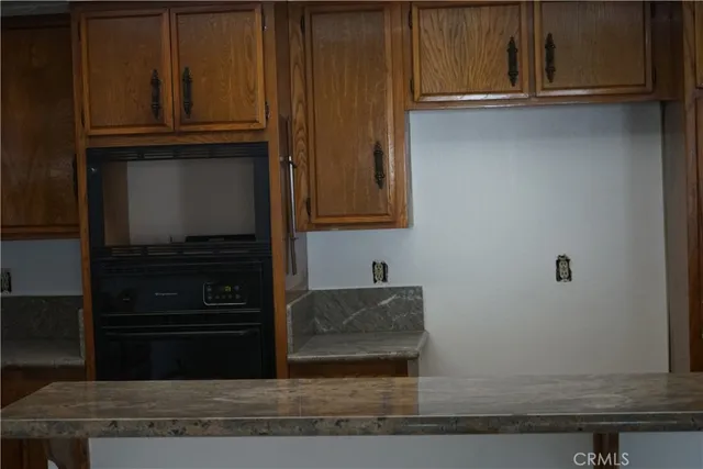 a kitchen with granite countertop white cabinets and stainless steel appliances