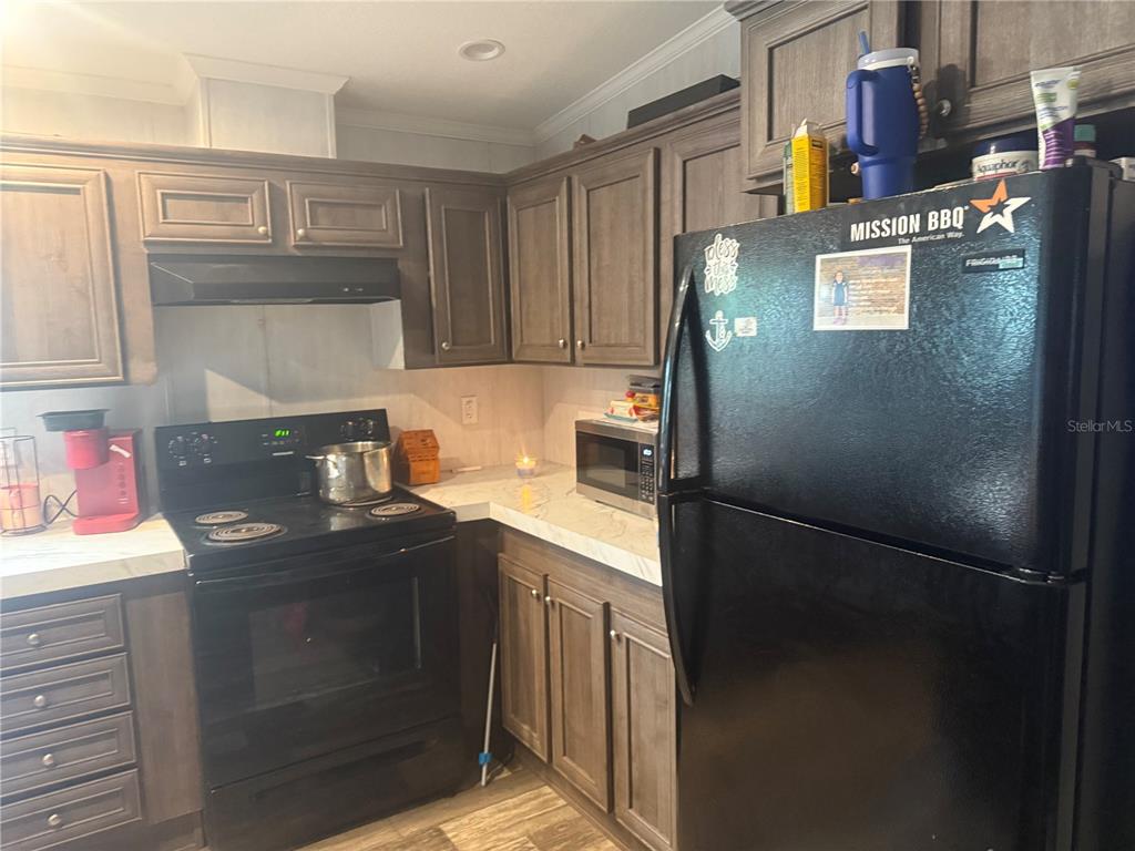 6505 Oil Well Road Clermont, FL 34714 - Photo 18 of 30 a kitchen with stainless steel appliances granite countertop a refrigerator and a stove