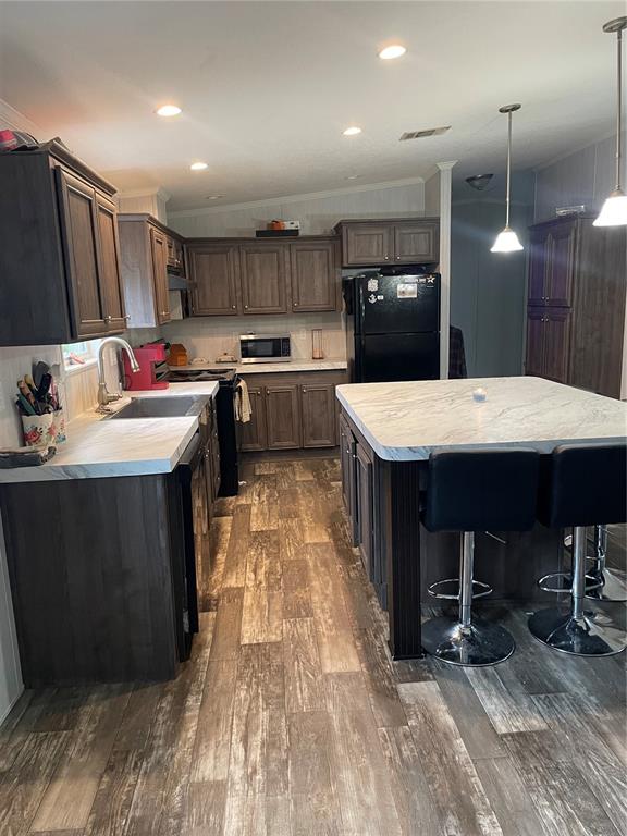 6505 Oil Well Road Clermont, FL 34714 - Photo 2 of 30 a kitchen with kitchen island a stove a refrigerator and a sink