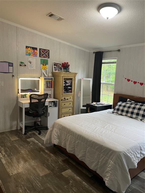 6505 Oil Well Road Clermont, FL 34714 - Photo 9 of 30 a bedroom with a bed and a chandelier