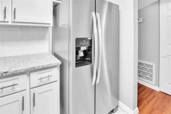a kitchen with granite countertop cabinets and refrigerator
