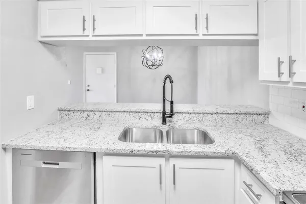 a kitchen with granite countertop a sink and cabinets