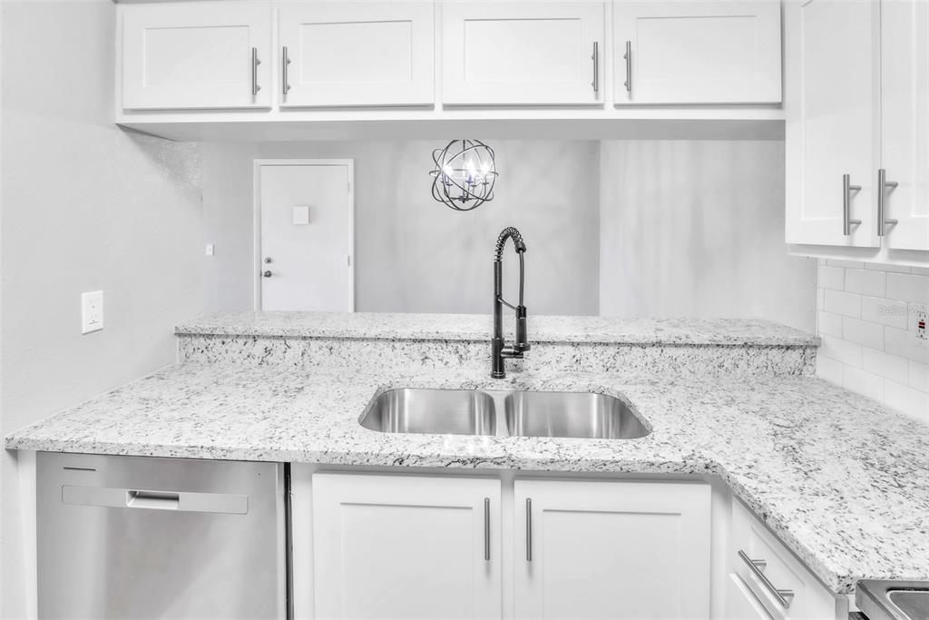 3281 South Beneva Road, Unit 202 Sarasota, FL 34232 - Photo 12 of 26 a kitchen with granite countertop a sink and cabinets