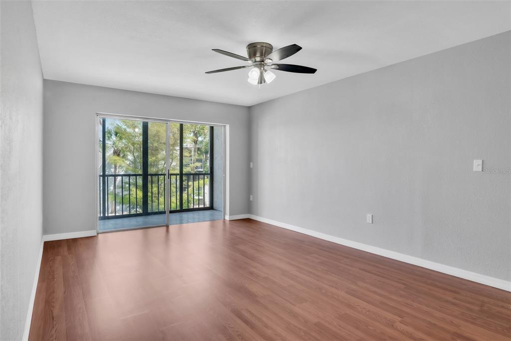 3281 South Beneva Road, Unit 202 Sarasota, FL 34232 - Photo 4 of 26 a view of an empty room with wooden floor and a window