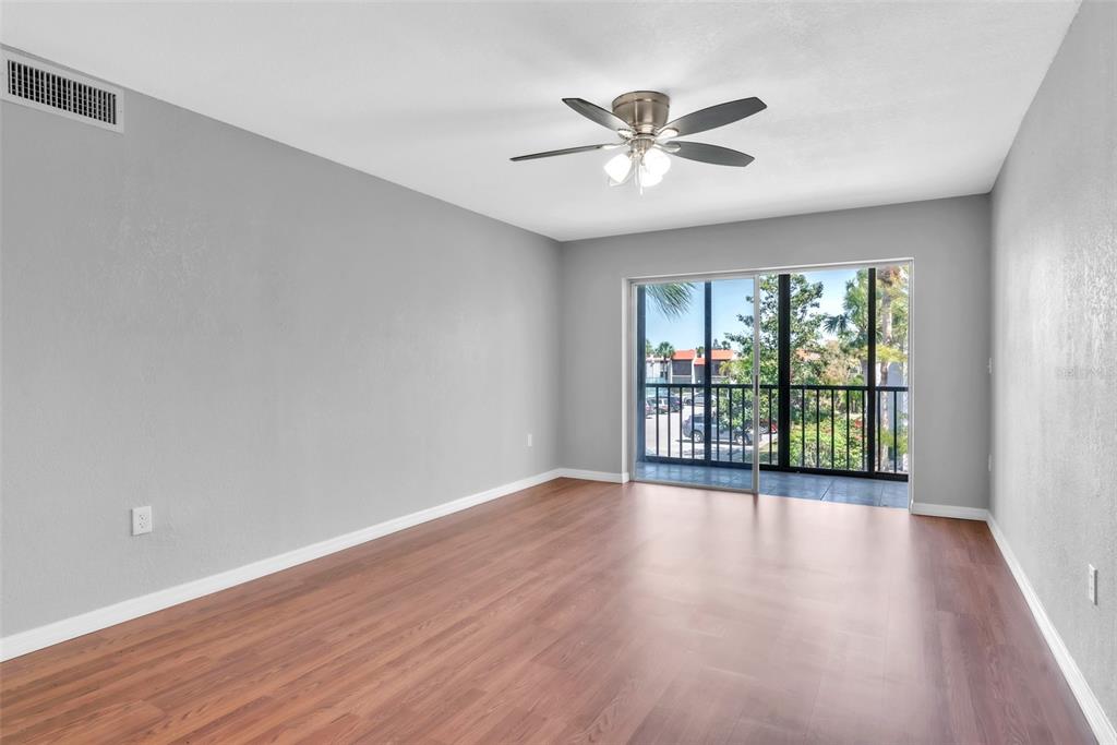3281 South Beneva Road, Unit 202 Sarasota, FL 34232 - Photo 5 of 26 a view of an empty room with wooden floor and a window
