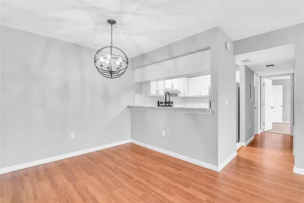 a view of a room with wooden floor fan and windows