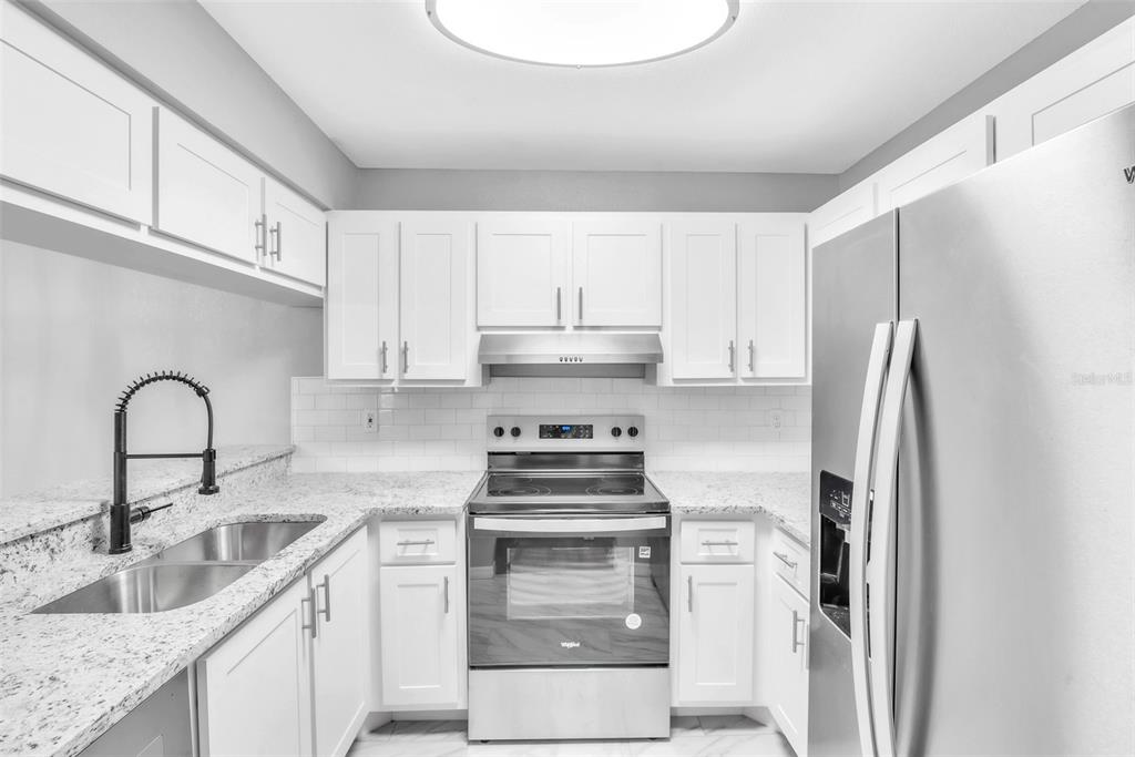 3281 South Beneva Road, Unit 202 Sarasota, FL 34232 - Photo 9 of 26 a kitchen with stainless steel appliances granite countertop a stove a refrigerator and a sink