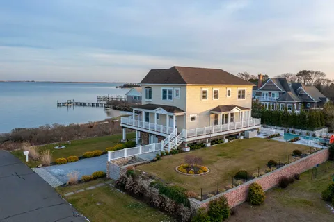 a view of a big house with a big yard and large tree