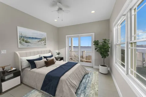 a bedroom with bed and a large window