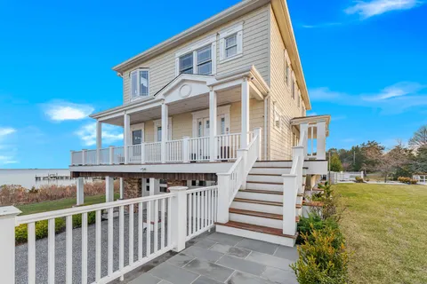 a view of a house with wooden deck and a backyard