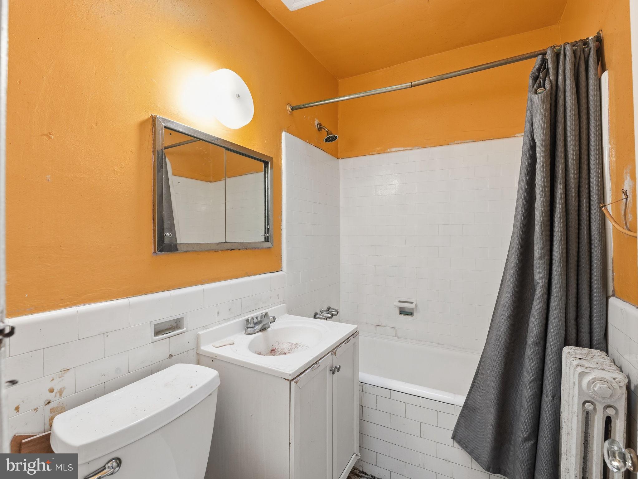 5733 9th Street Northwest Washington, DC 20011 - Photo 14 of 20 a bathroom with a sink a toilet and shower curtain