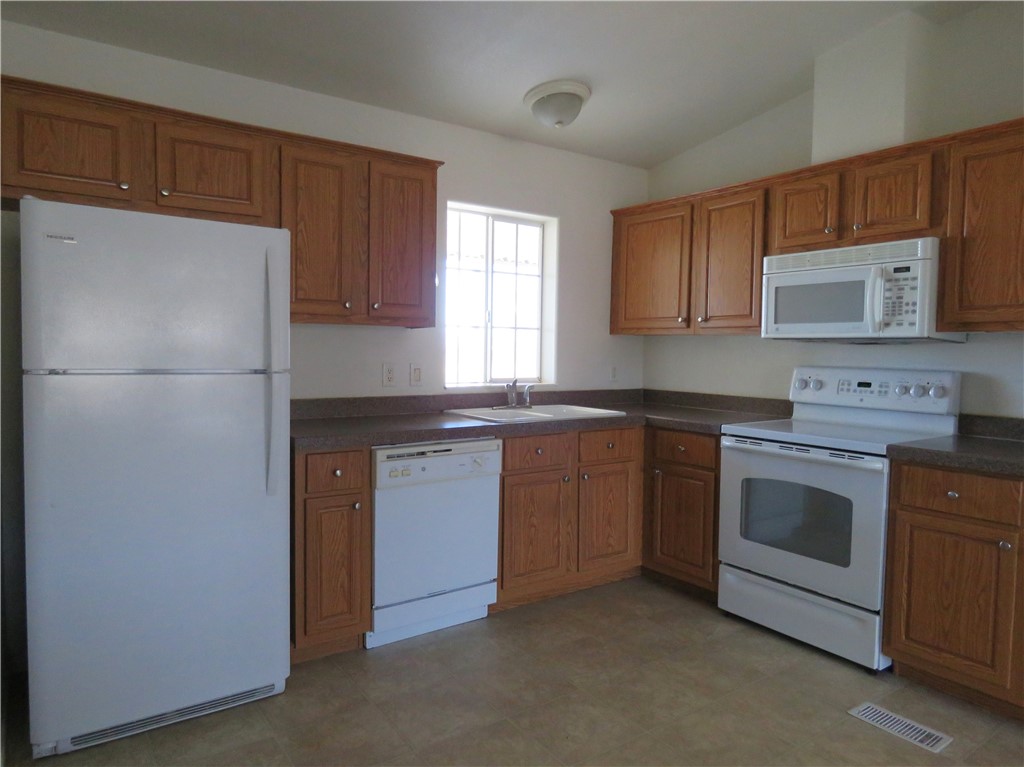 785 Bacobi Road Golden Valley, AZ 86413 - Photo 22 of 35 a kitchen with granite countertop a refrigerator stove and microwave