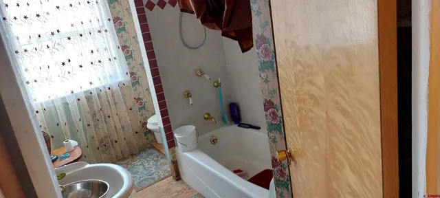 a view of wooden house with a small yard