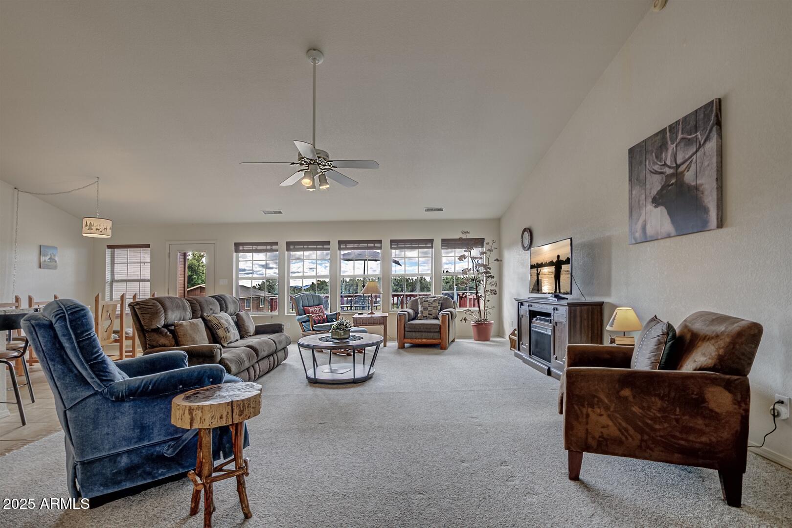 155 Claxton Road Payson, AZ 85541 - Photo 4 of 46 a living room with furniture a fireplace and large windows