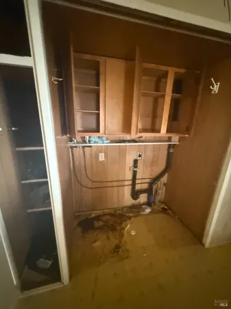 a room with water heater and wooden cabinets