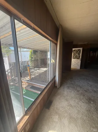 en empty room with windows and ceiling fan