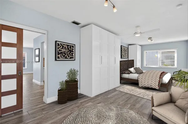 a spacious bedroom with a bed and wooden floor