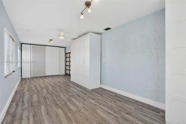 a view of an empty room with wooden floor