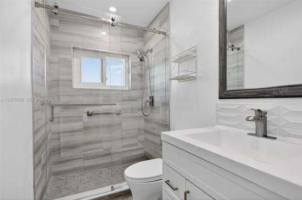 a bathroom with a sink a toilet and shower