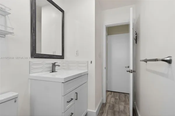 a bathroom with a sink and mirror with toilet