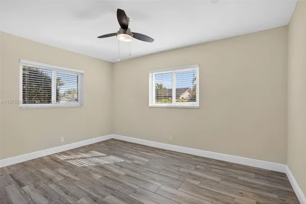 a view of empty room with wooden floor