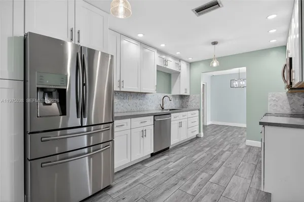 a kitchen with granite countertop stainless steel appliances and refrigerator