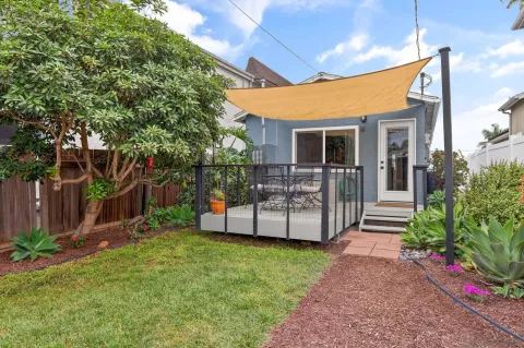 a view of a house with backyard and sitting area