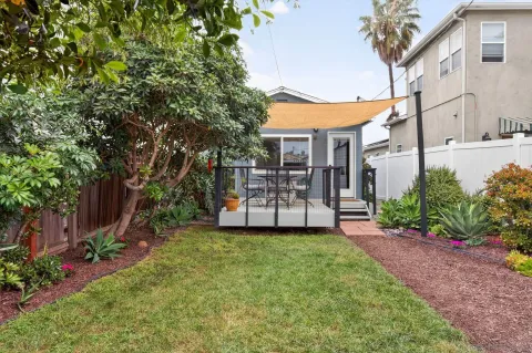 a view of a house with a yard and potted plants