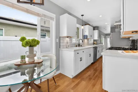 a kitchen with stainless steel appliances kitchen island granite countertop a table chairs and a refrigerator