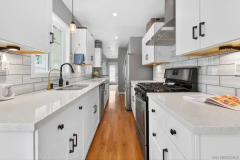 a kitchen with stainless steel appliances a sink a stove a refrigerator a center island and a stove