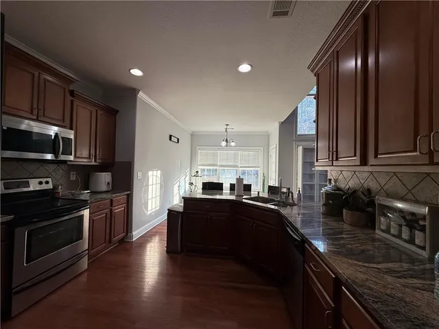a kitchen with stainless steel appliances granite countertop wooden cabinets a sink and dishwasher